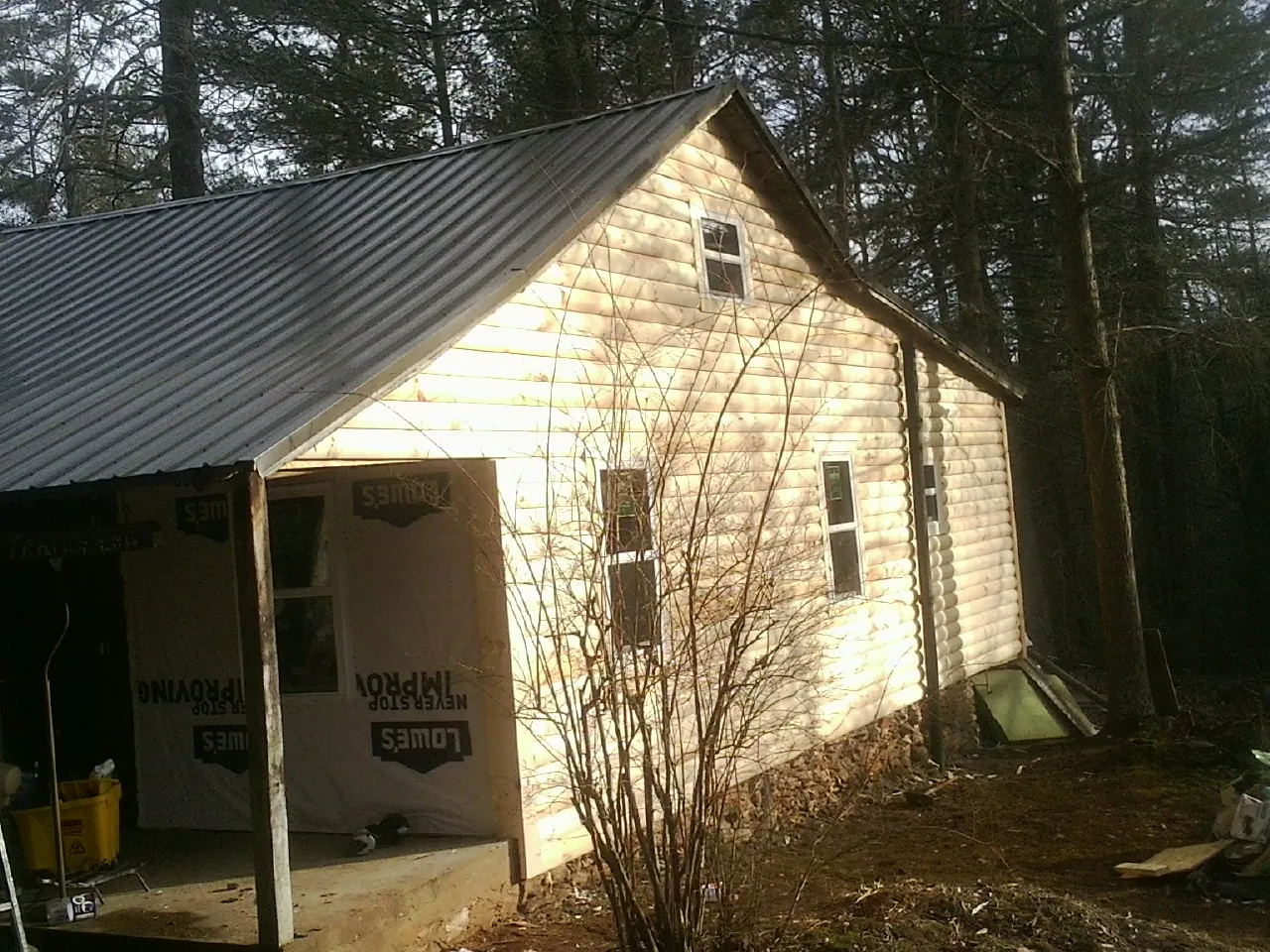 Log siding gable end under a dark metal roof edge in Boiling Springs