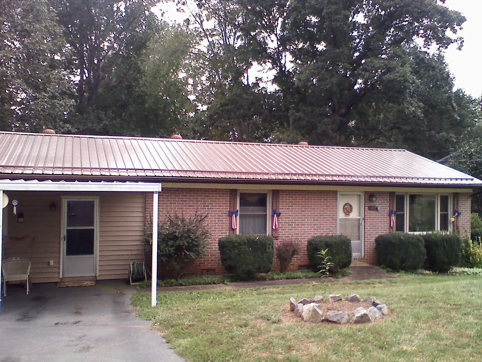 Bronze metal roof and carport on a brick ranch home — Roof Repair work by our crew in Boiling Springs